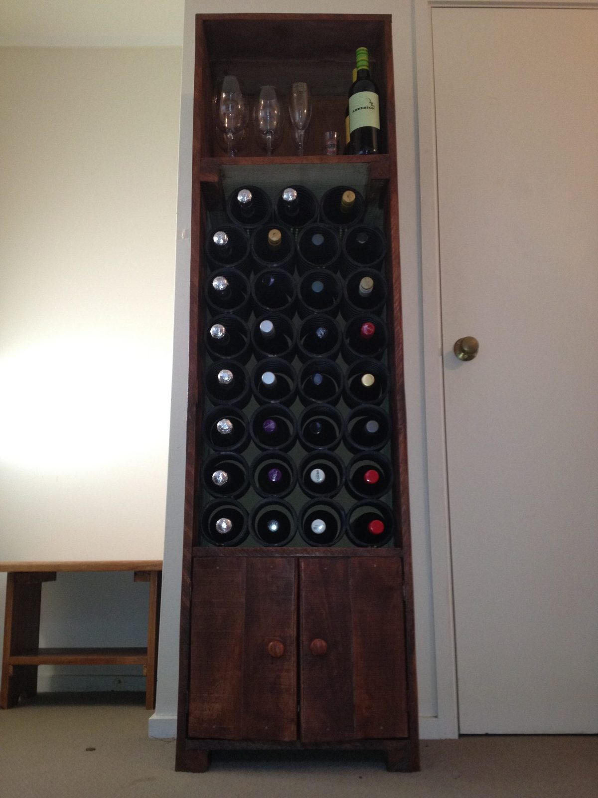 Wine rack bursting with bottles.