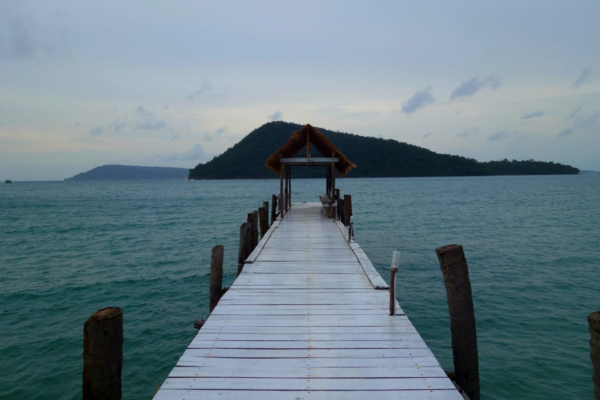 How to save $100k by age 25 cover image: a pier off the coast of Koh Rong island, Cambodia