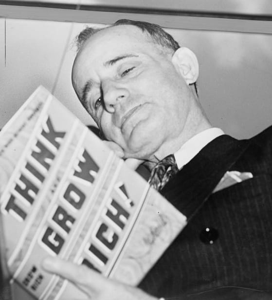 Napoleon Hill reads a copy of Think and Grow Rich