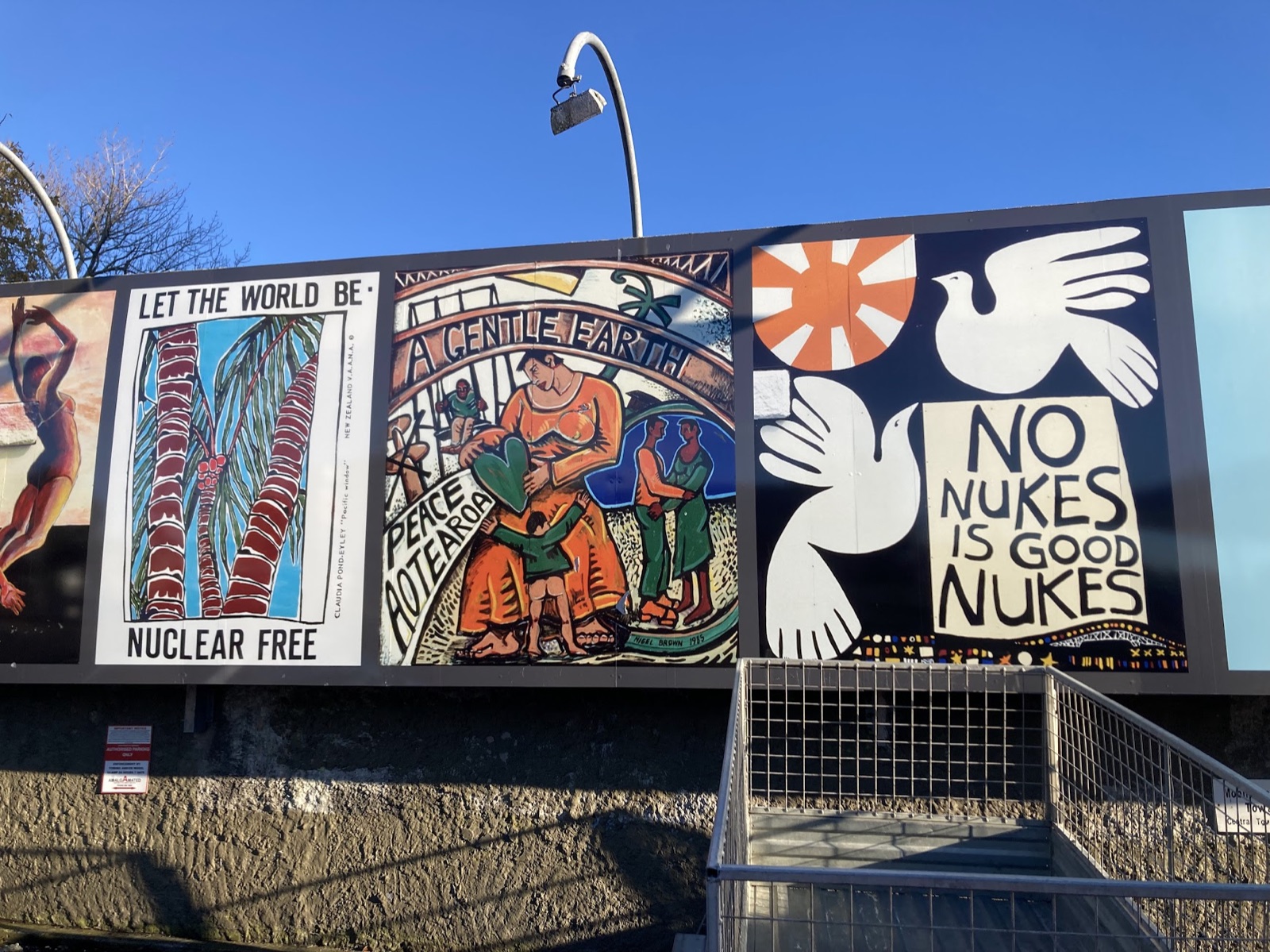 Anti-nuclear murals on a wall: 'Let the world be nuclear free', 'A gentle earth, peace Aotearoa', and 'No nukes is good nukes'